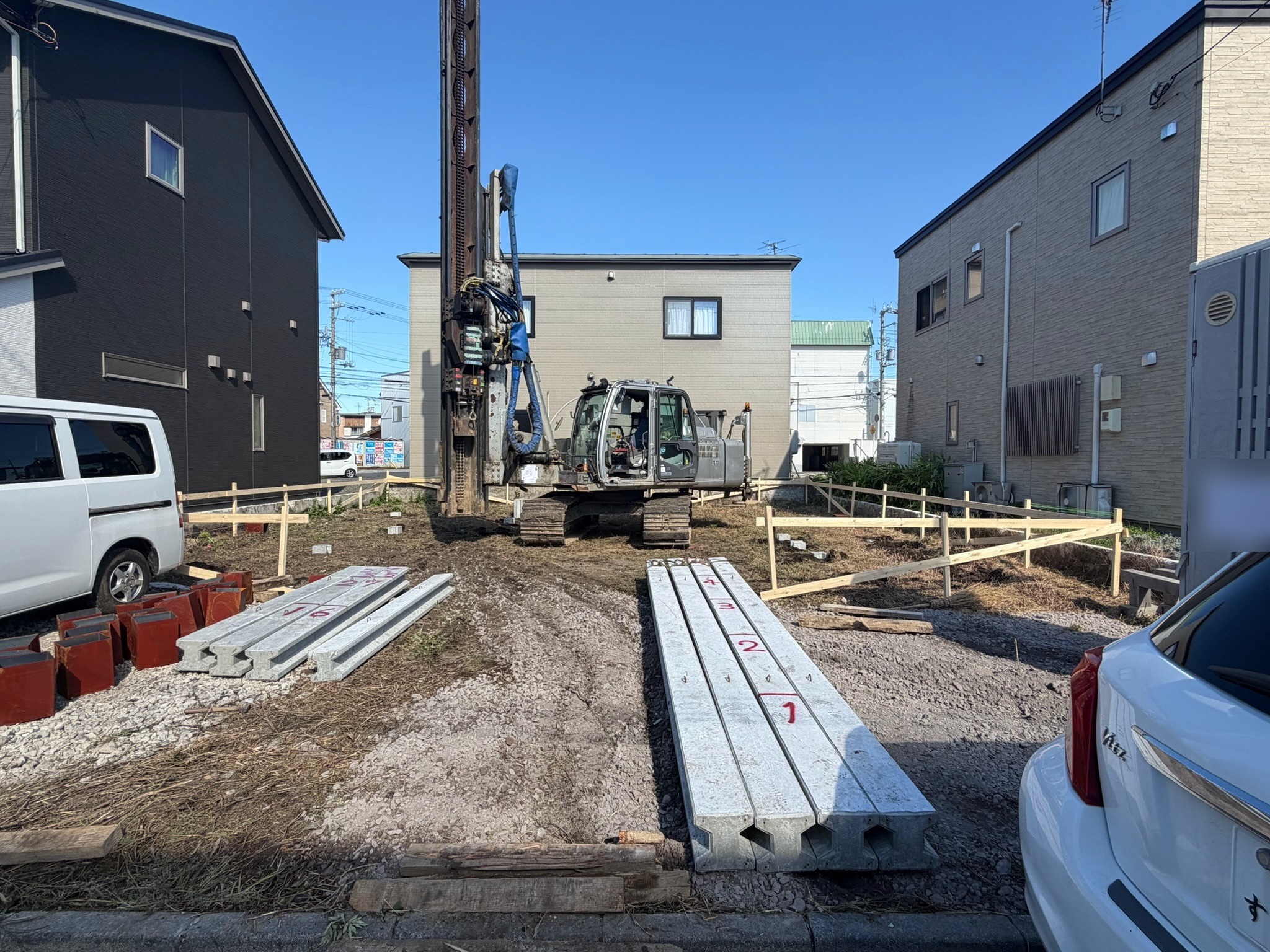 地盤改良と杭の工事をする大きな機械と、これから入れる杭